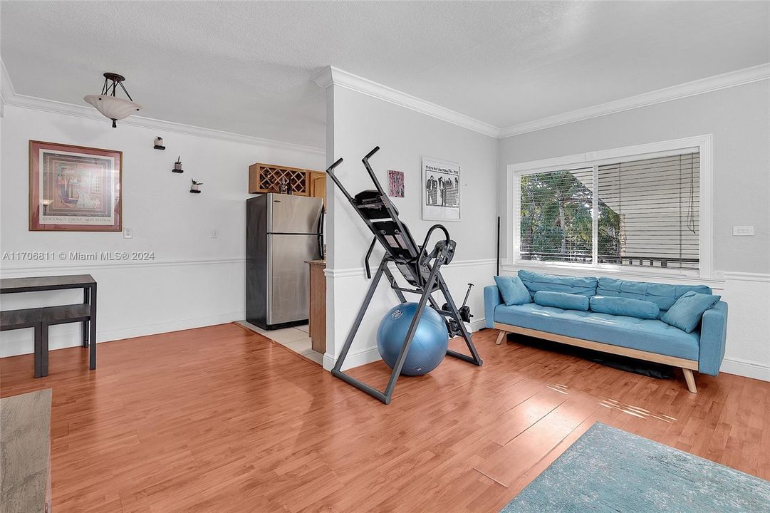 View of living room  towards dining area and kitchen. Crown moldings throughout the unit gives it a special unified look.