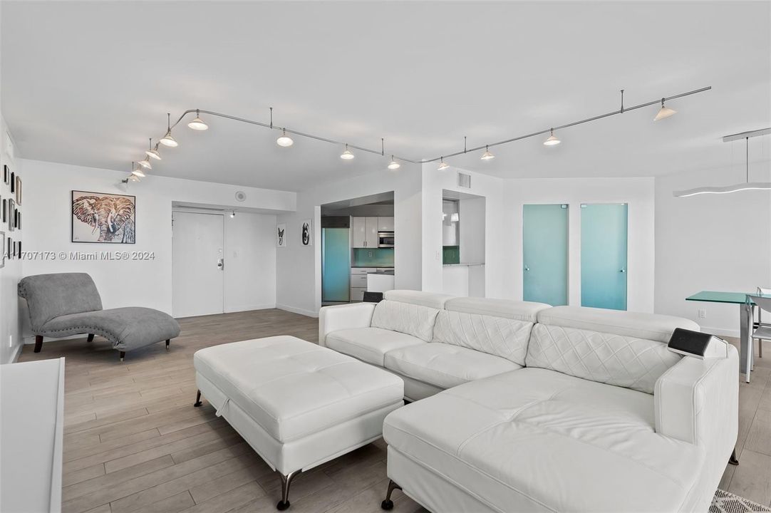 Living area with view to kitchen and front door