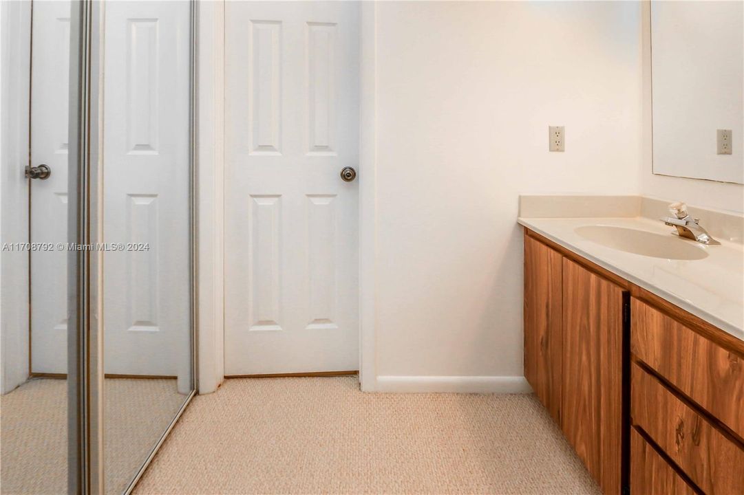 Sink, closet, dressing area adjacent to primary bedroom