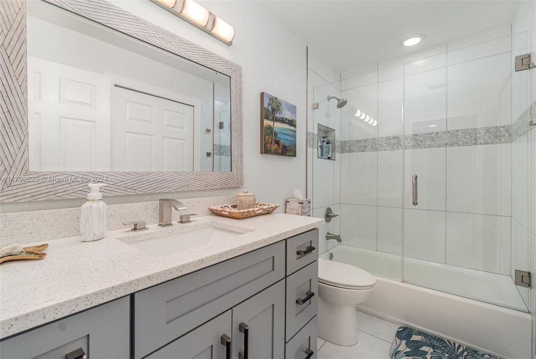 Renovated Guest bath with quartz countertops and new shower tile.