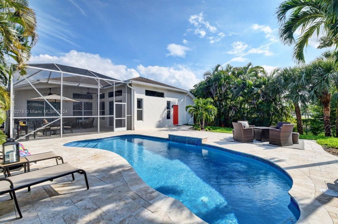 Large pool deck and adjacent screened in room.