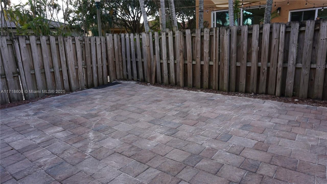 Fenced patio with paver.