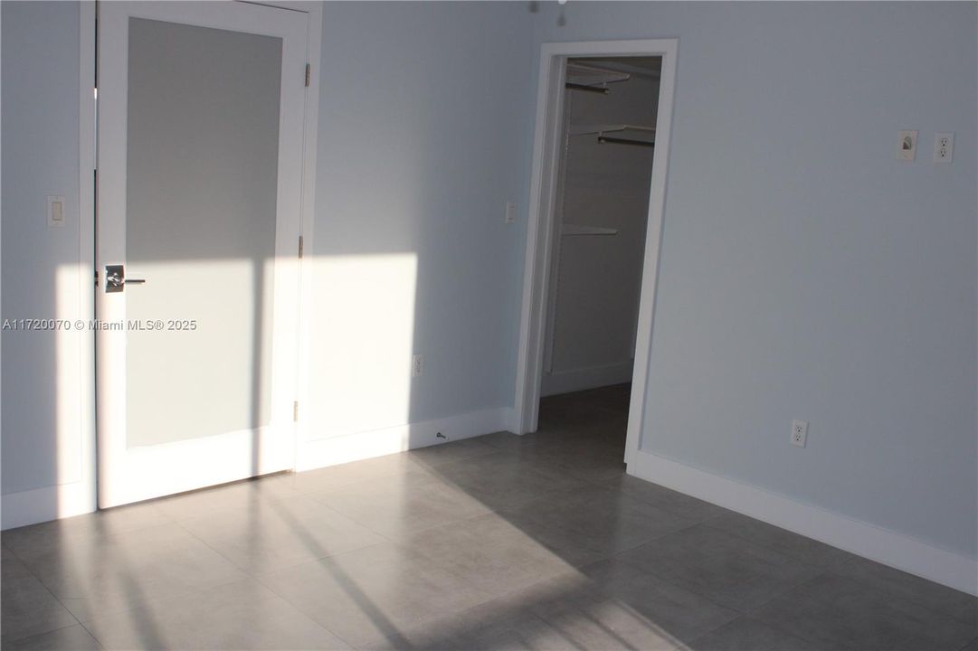 MASTER BEDROOM WITH SLIDDING DOORS TO SCREENED BALCONY AND VIEW OF POOL