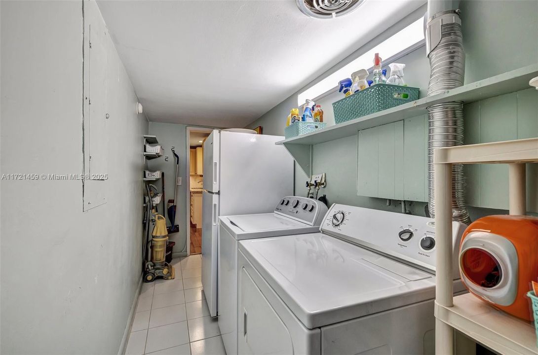 Laundry room with full sized washer and dryer, plus extra full sized refrigerator, located off kitchen in the center of the home. Great location w/ a utility door to the side yard