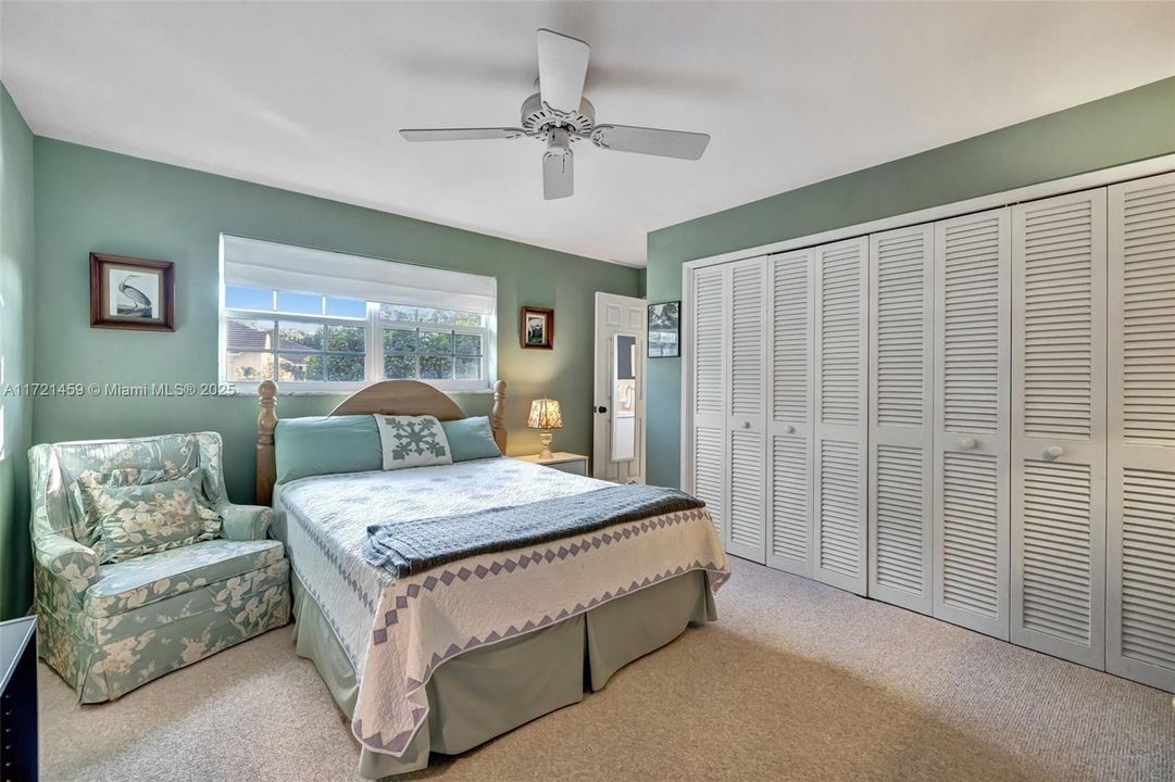 Large guest bedroom w/ wall to wall closet overlooks the side yard