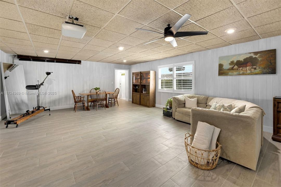Family/media room with acoustic ceilings offering space for higher ceilings, 2023 porcelain floors