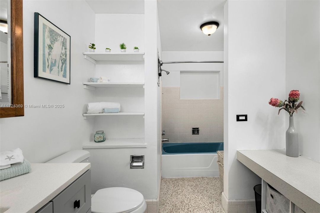 Bathroom 2 with terrazzo floors in pristine condition, shower/tub and dressing table