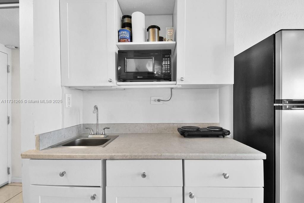 Fully equipped kitchen with quartz countertops, white cabinetry, and stainless steel appliances—ideal for short- or long-term stays.