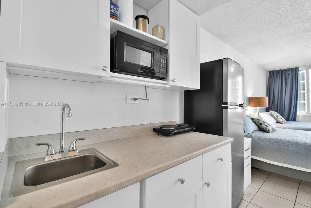 Contemporary kitchen with ample storage, elegant backsplash, and modern finishes. Perfect for hosting or extended stays in Sunny Isles Beach.