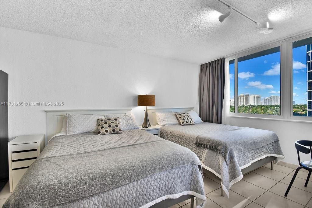 Cozy guest bedroom with plenty of natural light, ideal for vacation guests or rental income potential.