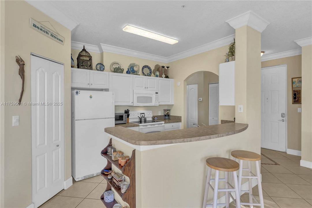 Kitchen with snack bar has ample space and seating.