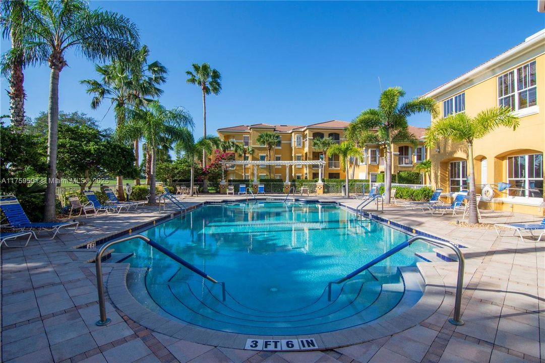 Community pool are with rows of poolside seating and sun chairs. Pool is heated in winter and cooled in summer.