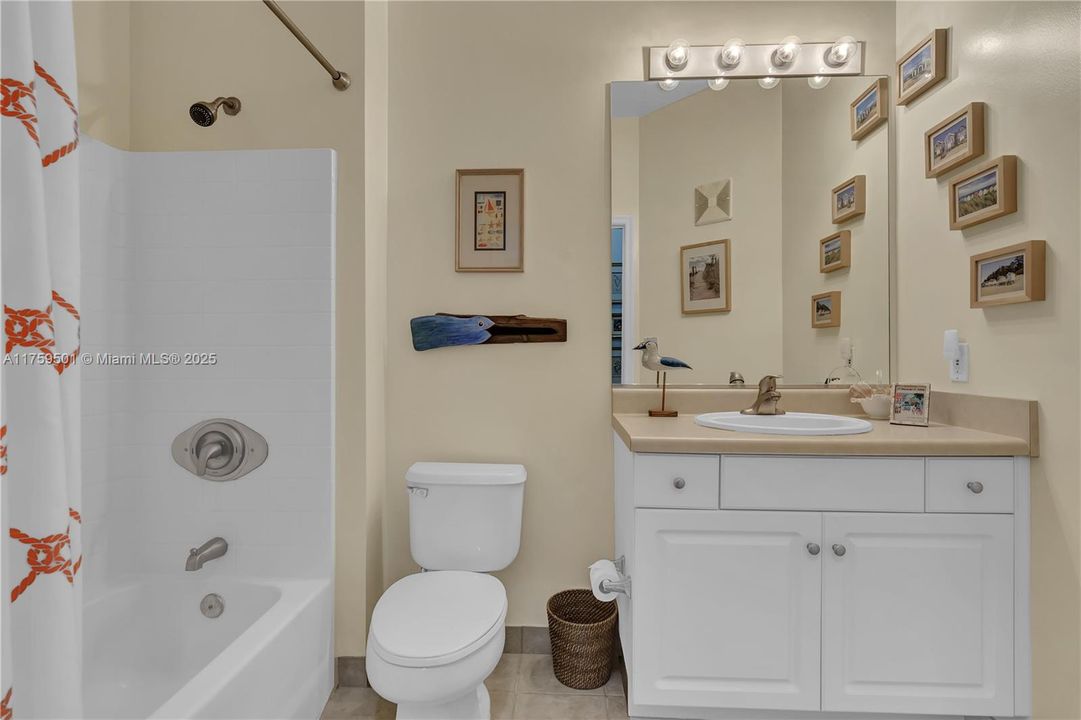 Guest bath functions as powder room for visitors but is complete with shower/tub WC and sink and vanity.