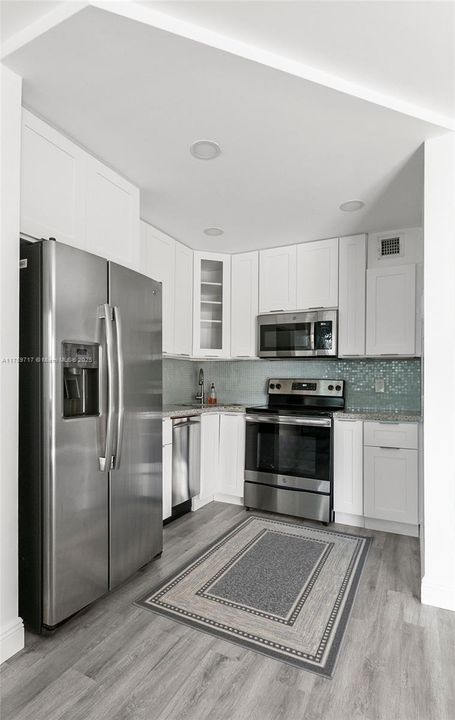 Modern sleek kitchen with recessed lighting, and no popcorn ceiling here! All appliances are stainless steel in mint condition, barely used! Plenty of storage with lots of cabinetry for the Chef in the kitchen!