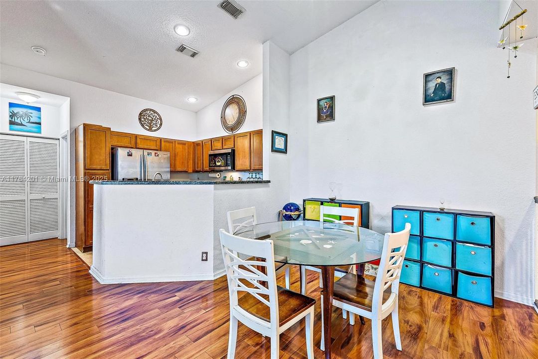 Dining Area, open Kitchen and Living Room with vaulted ceilings, knockdown texture walls and wood-look laminate flooring.
