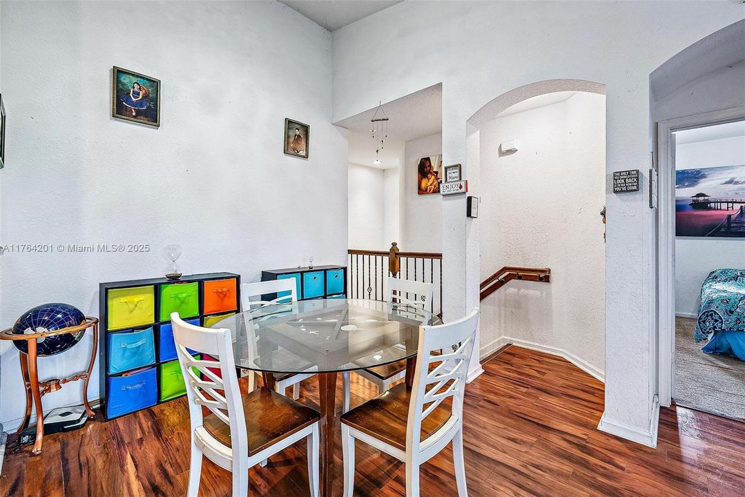 Entry to open Dining Area, Kitchen and Living Room with vaulted ceilings, knockdown texture walls and wood-look laminate flooring.