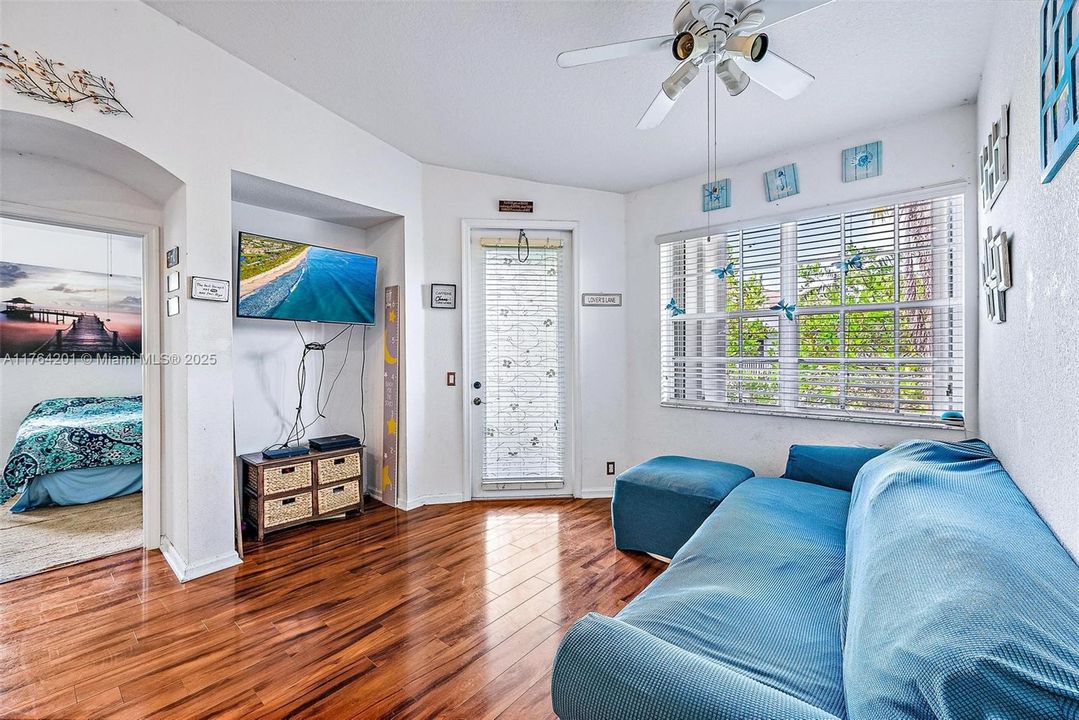 Living Room with access door to outdoor balcony. Vaulted ceilings, knockdown texture walls and wood-look laminate flooring.