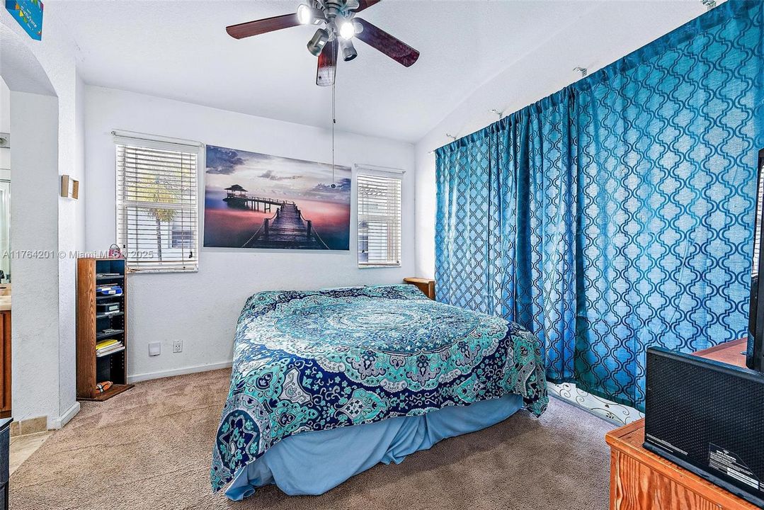 Primary Bedroom with ensuite bathroom and walk-in closet. Slider doors to access outdoor balcony.