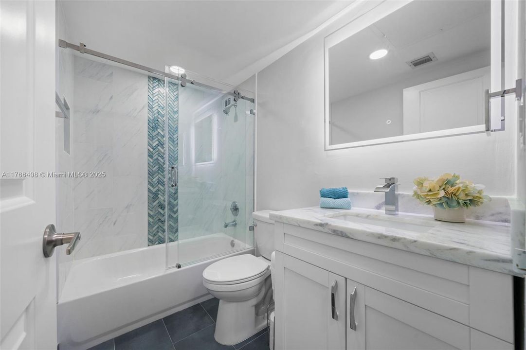 Second bathroom, complete with a bathtub for a relaxing experience, fully renovated with permits in 2023. Additionally, it features a shut-off valve under the sink for added convenience when going on vacation, ensuring peace of mind.
