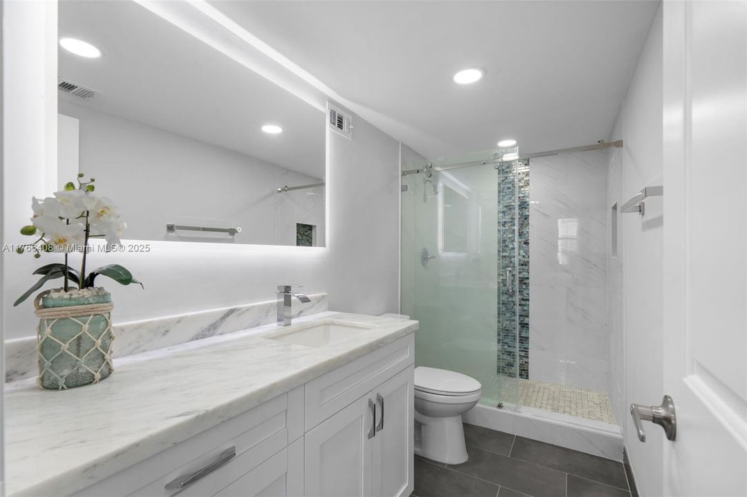 Master bathroom with a fully renovated shower, completed in 2023 with permits. Additionally, the bathroom features a shut-off valve under the sink for peace of mind when you’re away on vacation.