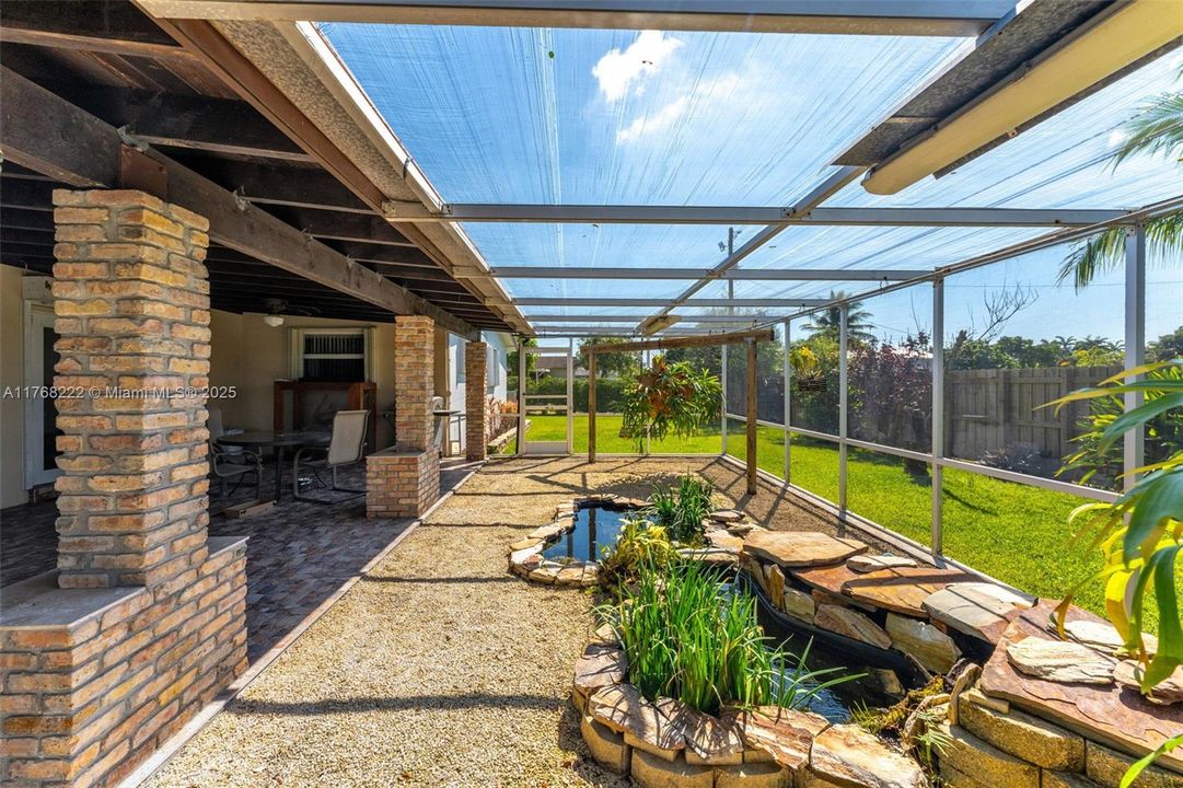 PERMITTED SCREENED PATIO WITH BEAUTIFUL KOI POND.  ROOM FOR A POOL.