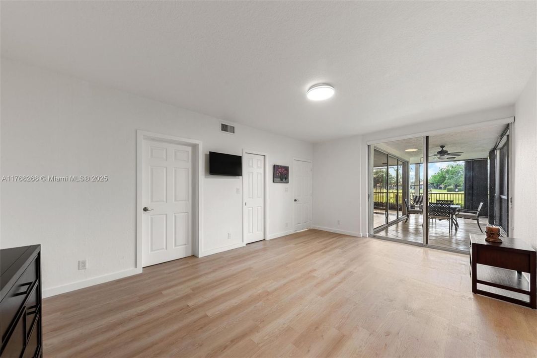 PRIMARY BEDROOM WITH WALK IN CLOSET AND VIEW OF GARDEN