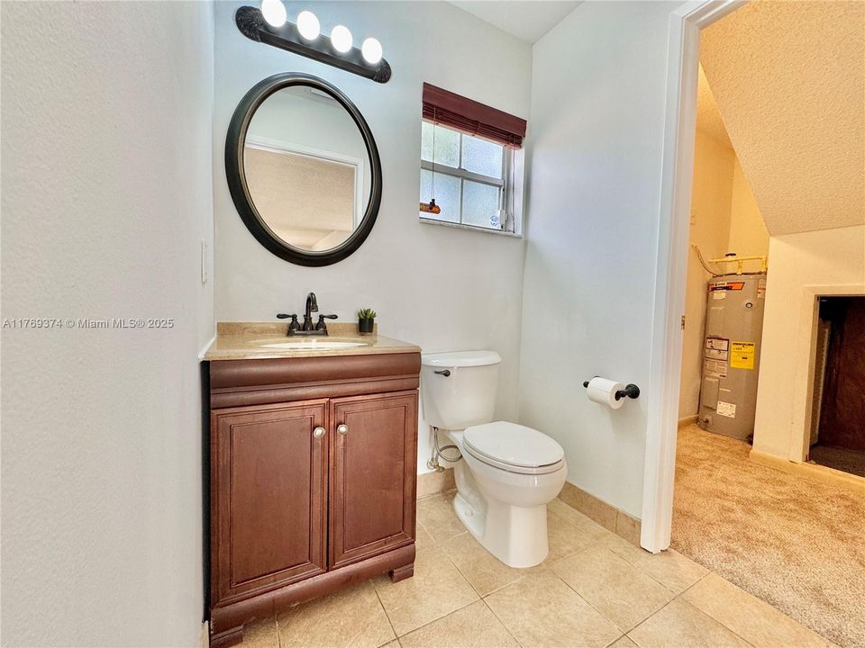 Half bath downstairs houses additional closet for storage nook.