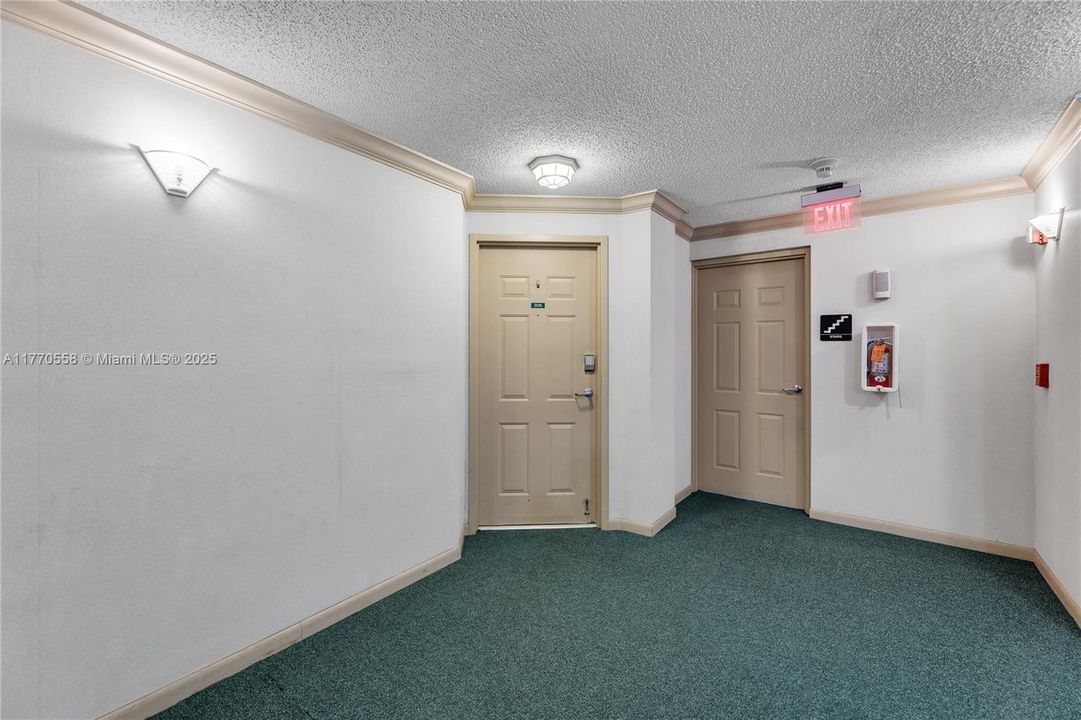 Interior hallway. Close to emergency stairs, not far from elevator