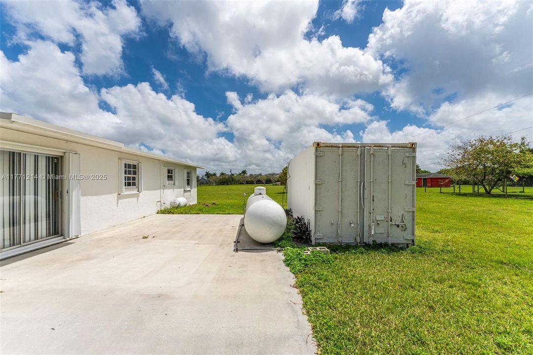 VIEW OF THE INSULATED A/C CONTAINER & 1000 lb PROPANE TANK.