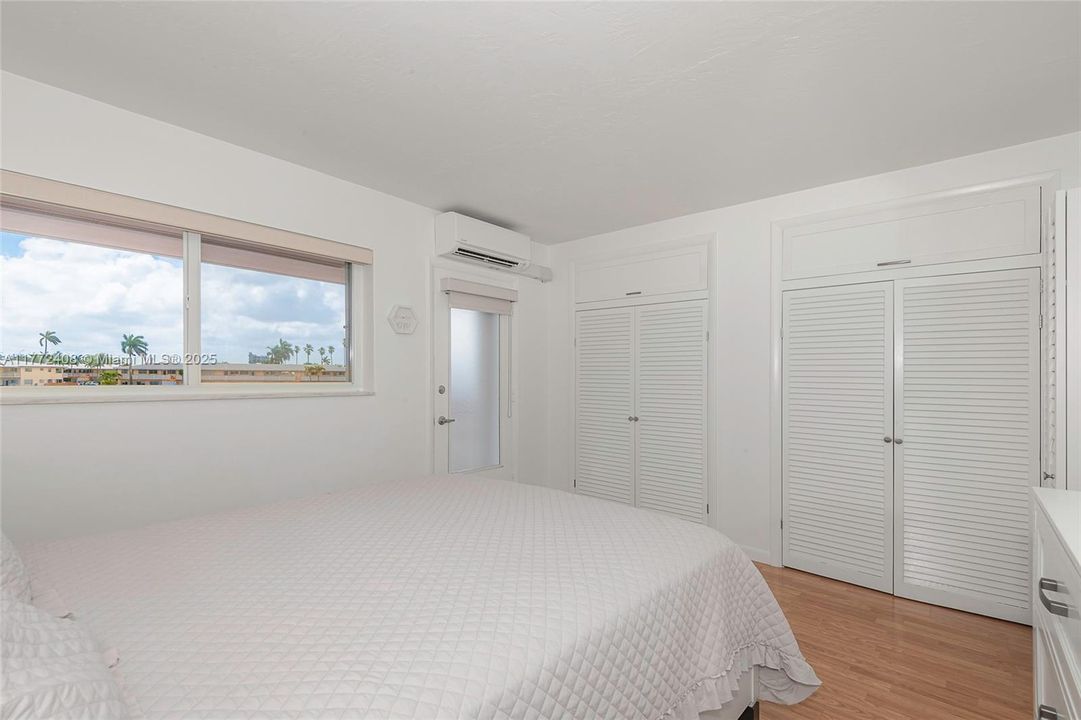 Large window in bedroom has blinds