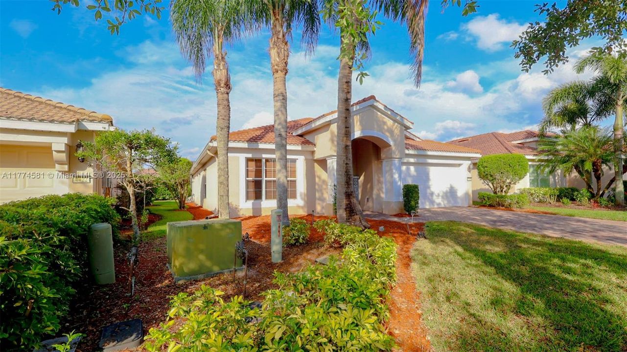 Mediterranean / spanish-style house with driveway, a garage, a front yard, a tile roof, and stucco siding