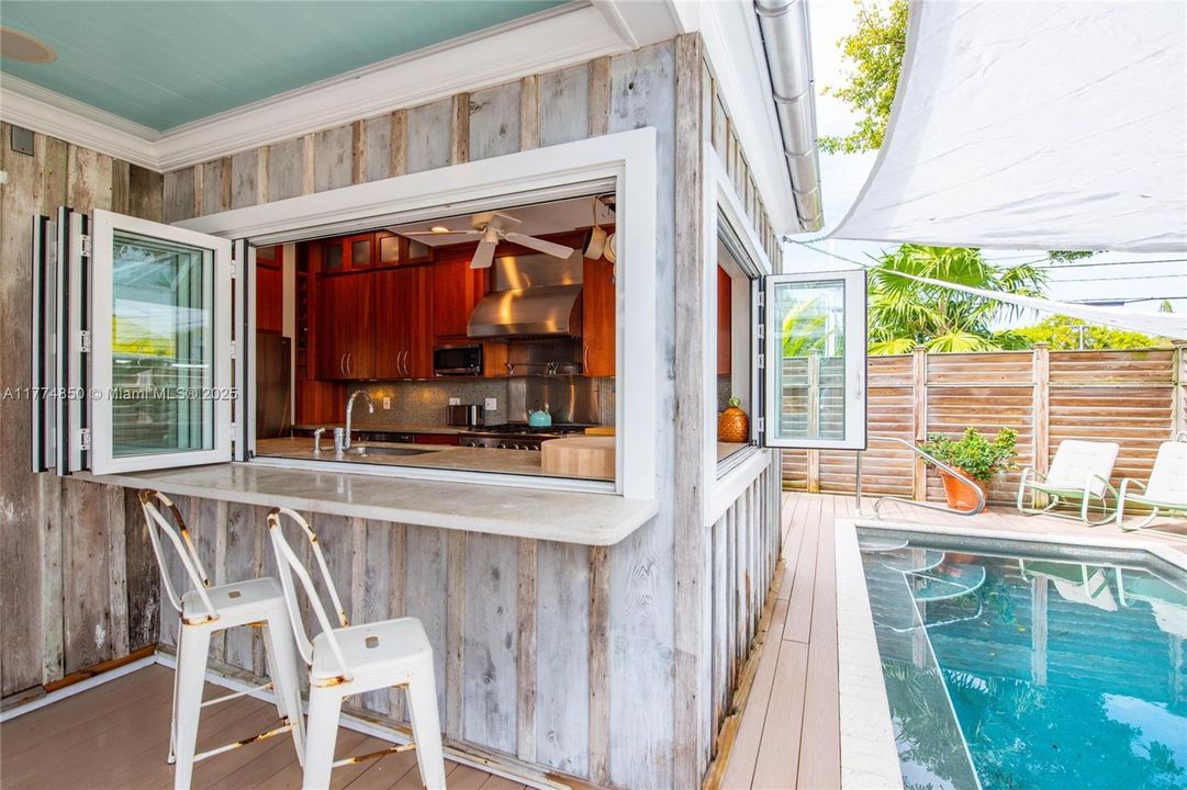 Kitchen bi-folding windows open to the pool area