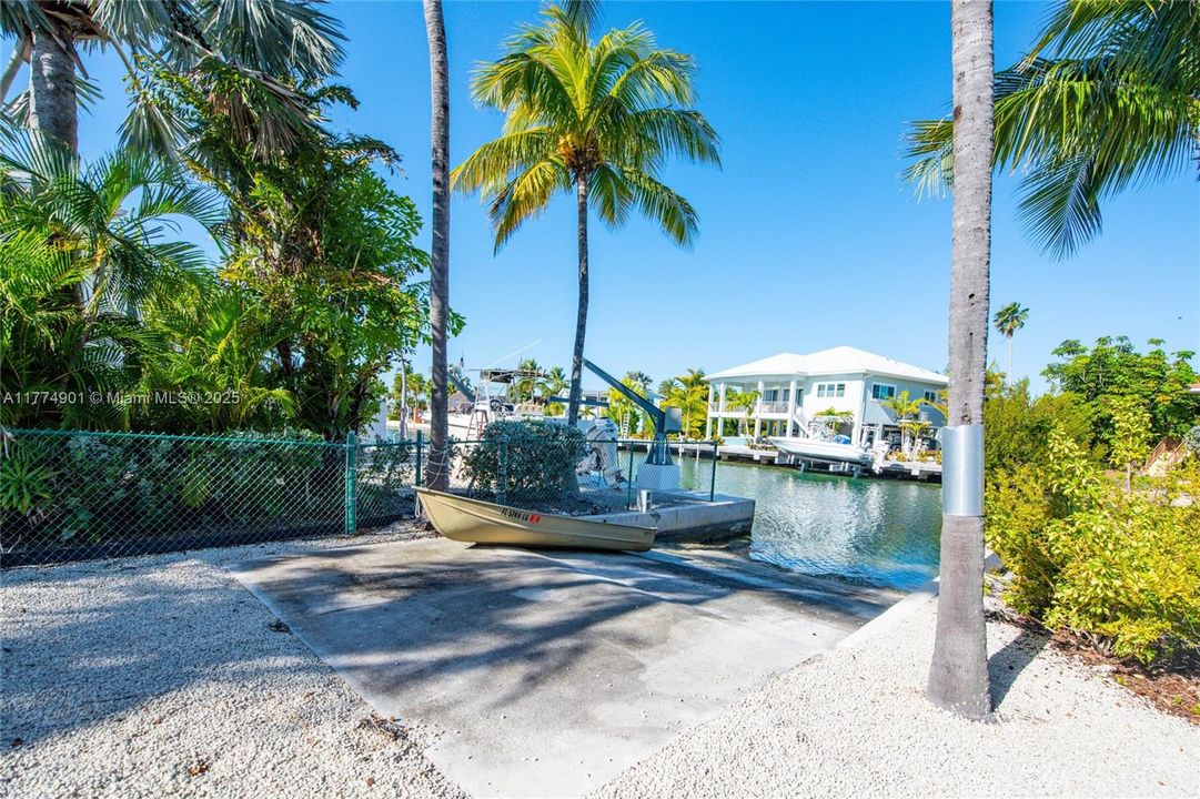 Seawall with boat ramp, davits and boat lift on swimming canal.