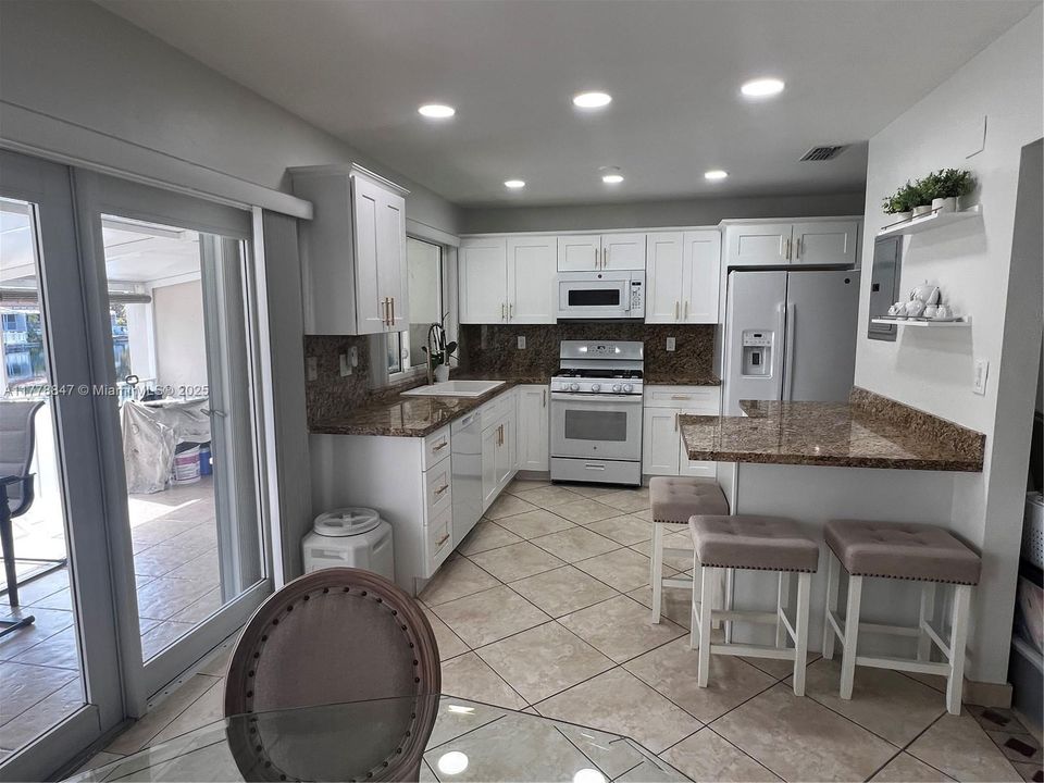 Newer kitchen cabinets and appliances, gas stove, cozy breakfast counter.