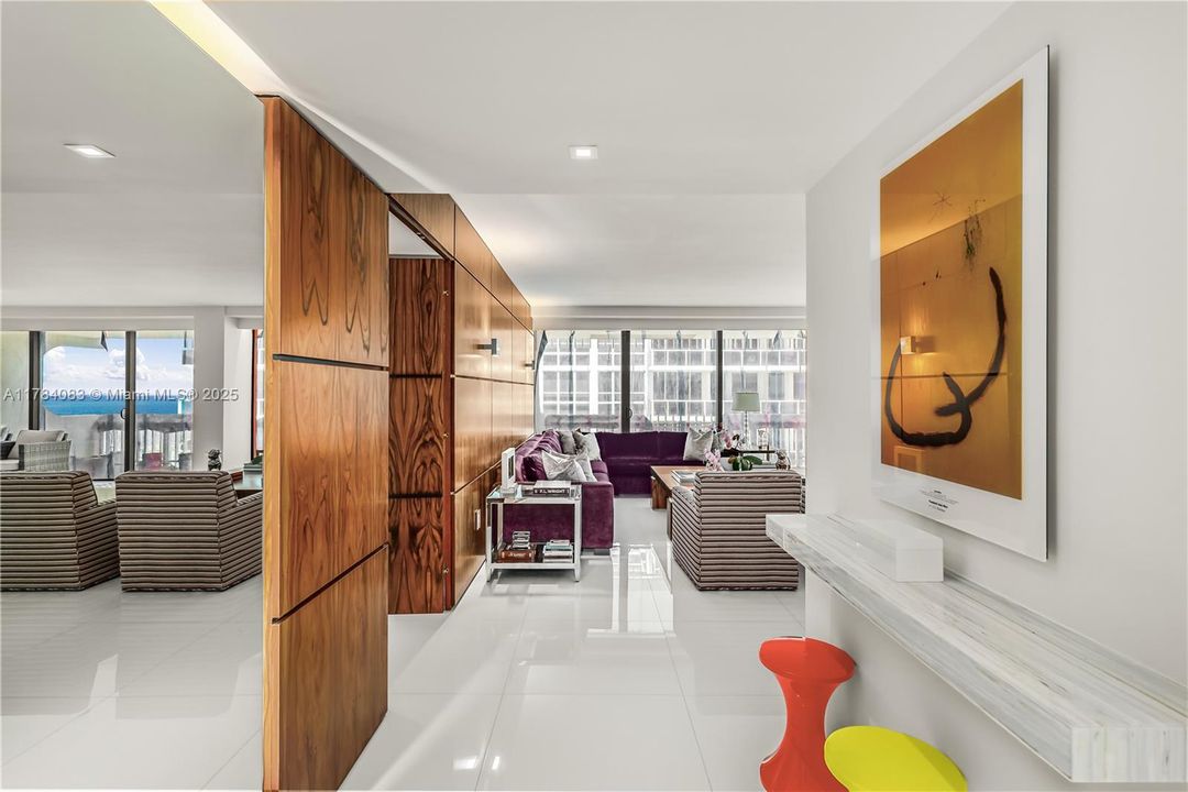 Elegant foyer entrance w/ stunning  rosewood custom walls an back lit mirror.