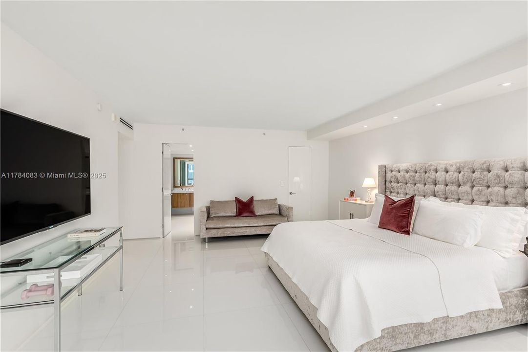 Enormous primary bedroom suite with seating area and walk in closets.