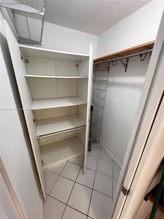 Walking closet with wardrome and clothes bar.