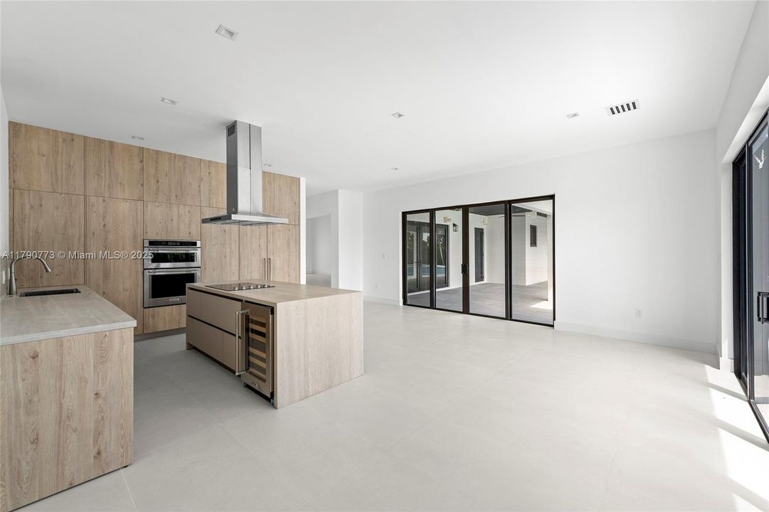 The heart of the home boasts a chef-inspired kitchen with a fully integrated, 48-inch panel-ready JennAir refrigerator, merging top-tier functionality with refined, modern aesthetics.