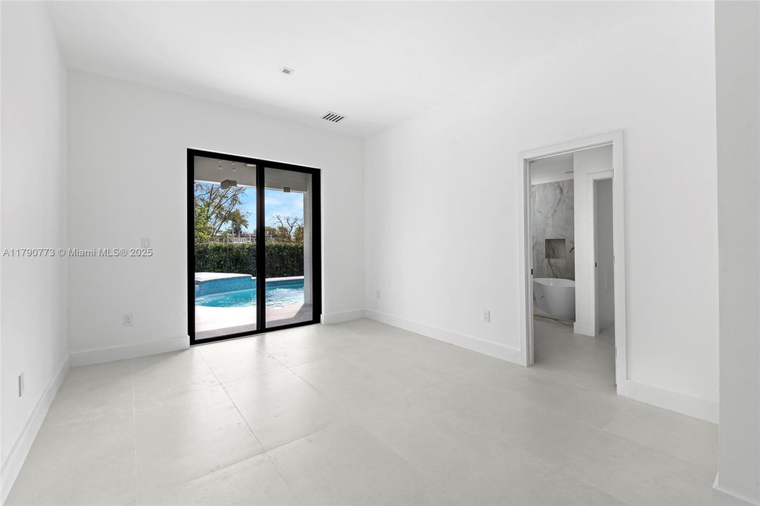 The elegant primary bedroom flows out to the secluded backyard retreat, where a free-form pool and heated sauna await.