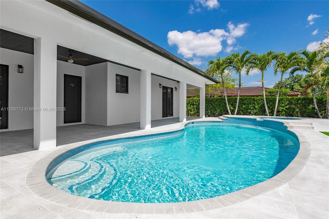 Enjoy a stunning free-form pool paired with a heated sauna, creating the ultimate backyard retreat for relaxation and entertaining.