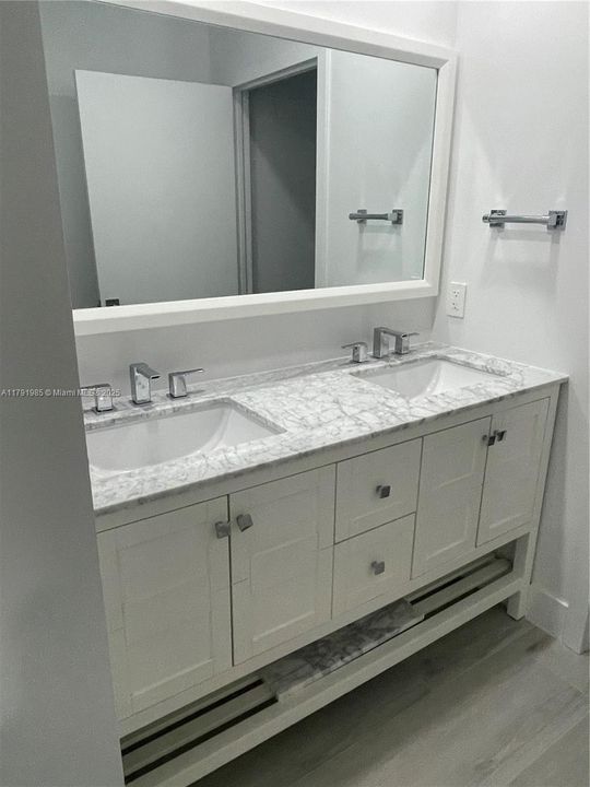 Master vanity with double sinks and marble countertop.