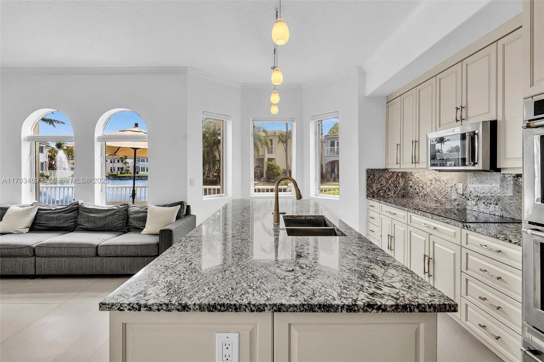 Gourmet Kitchen has high ceilings and is open to the family room and dining room ALL overlooking the point lot of the lake with the best views in all of Aventura Lakes! Features include 2 dishwashers, 2 ovens, double sink, huge beautiful island with so much storage, beautiful countertops and backsplash, and a custom bonus butler's pantry!