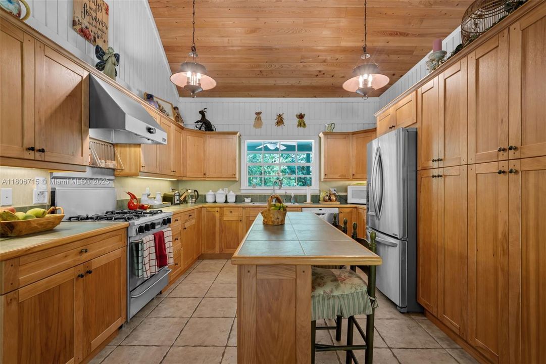 CENTER ISLAND HARDWOOD CABINETS. STAINLESS APPLIANCES..