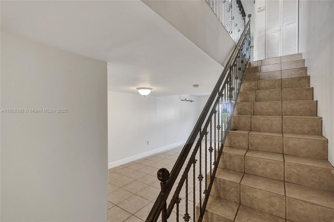 Notice staircase is also tiled to match and boasts a beautiful railing.