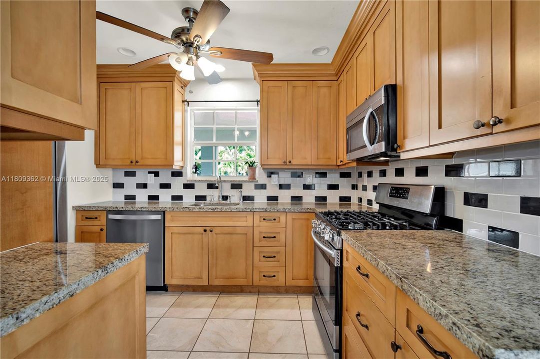 Solid wood cabinets with granite countertops and tiled backsplash