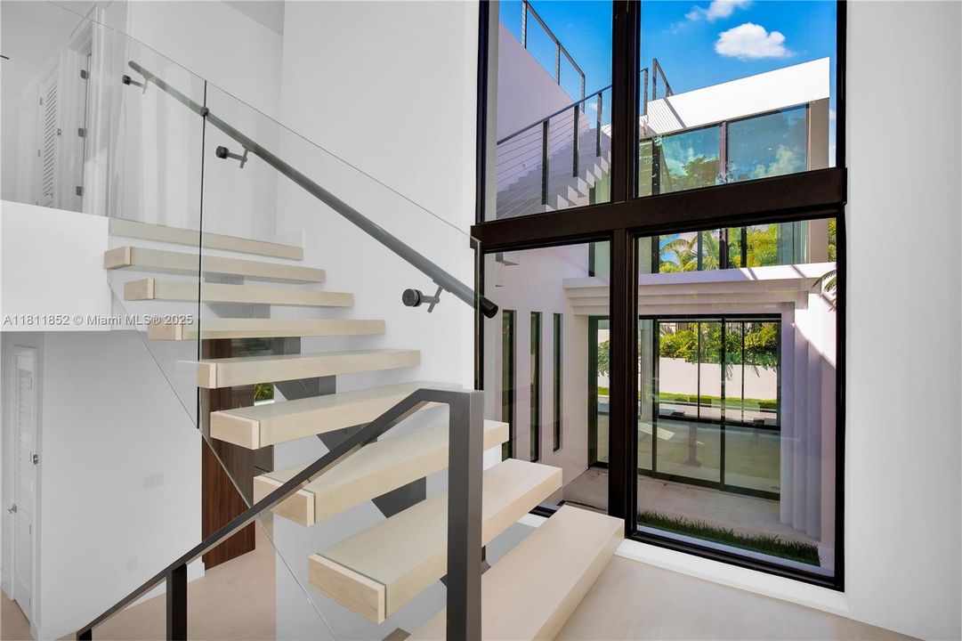 Staircase leading up to the second floor with glass windows on both sides of the staircase