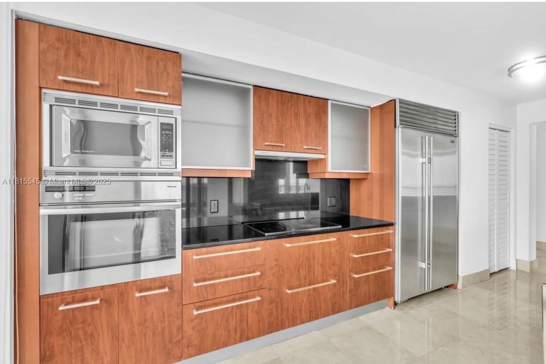 Built-In Coffee Maker, Wall Oven, Microwave/Oven Combo, Electric Cooktop, Vent hood, Sub-Zero Built-In Refrigerator & Freezer, Built-In Wine Cooler, Double Stainless Steel Sink.