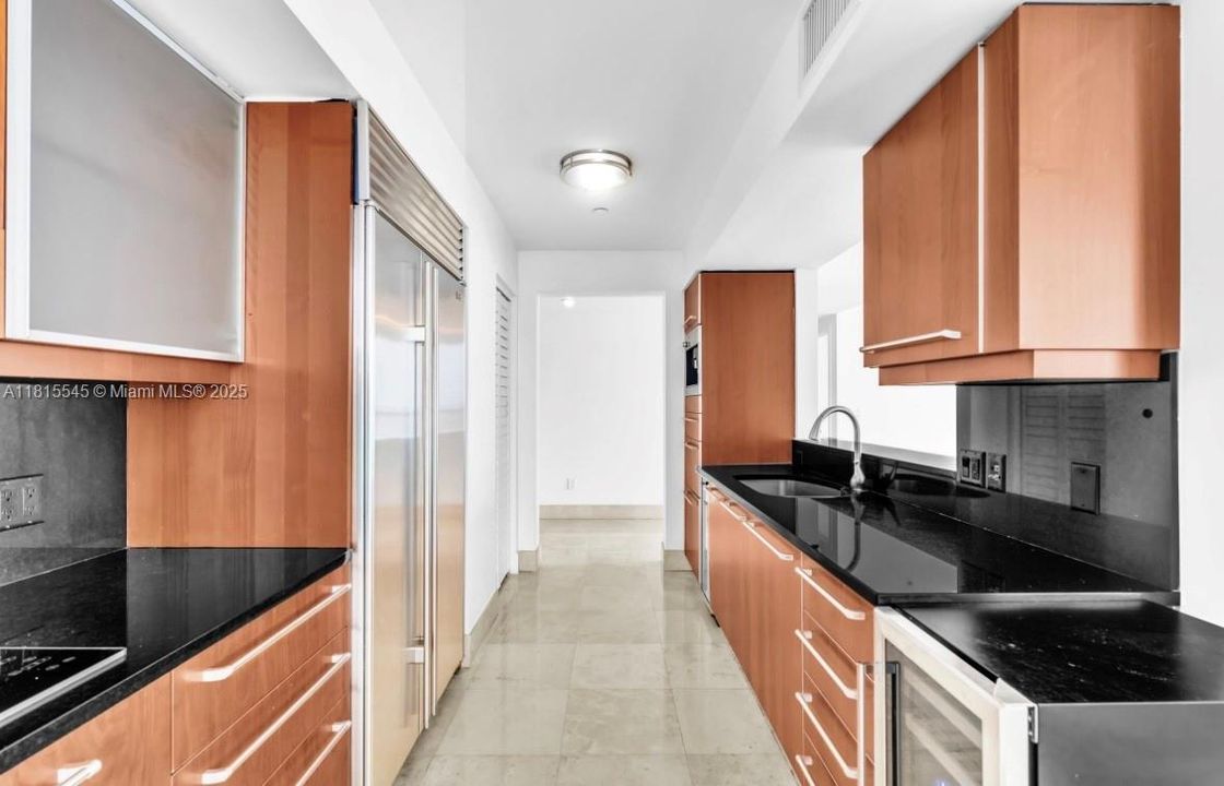 Built-In Coffee Maker, Wall Oven, Microwave/Oven Combo, Electric Cooktop, Vent hood, Sub-Zero Built-In Refrigerator & Freezer, Built-In Wine Cooler, Double Stainless Steel Sink.