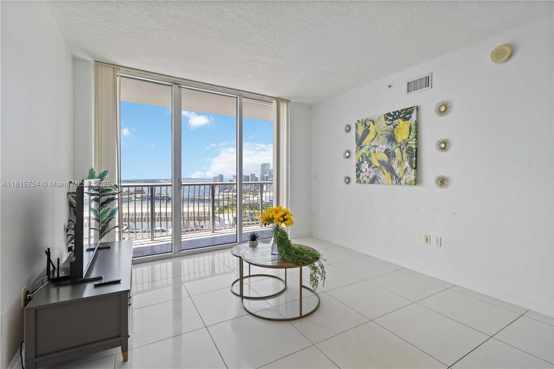 Spacious living area with modern tile flooring and contemporary design — ideal for entertaining with a view of Biscayne Bay.
