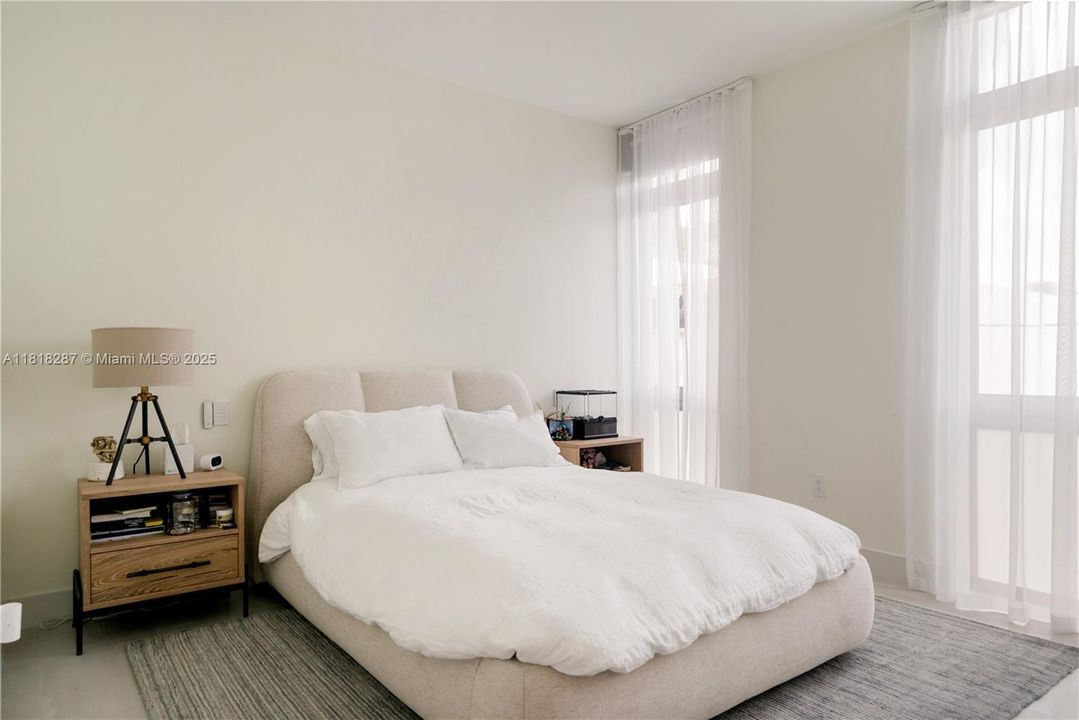 Second guest bedroom with corner windows and spacious layout.
